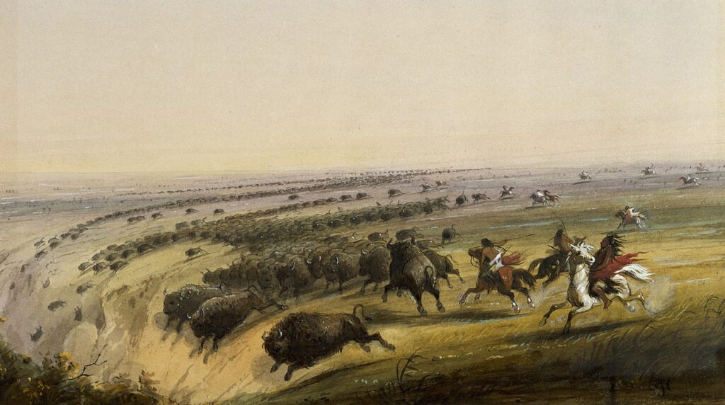 A painting of Native Americans on horseback hunting buffalo