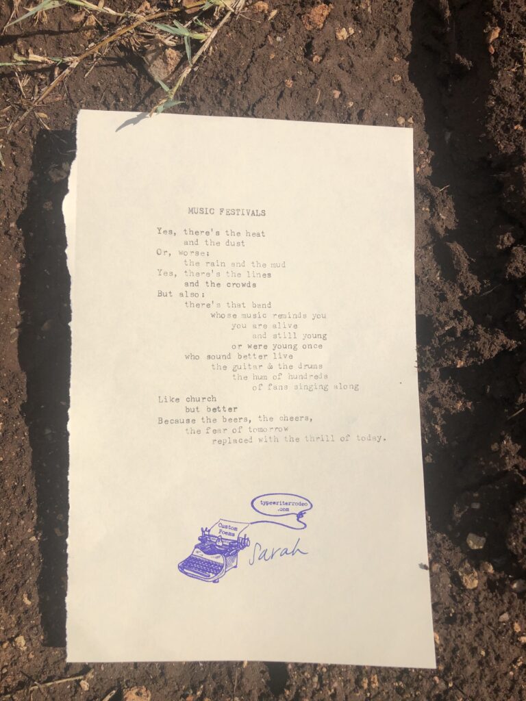 a photo of the typewritten poem on a torn half sheet of yellowish paper. the paper is sitting in the mud.
