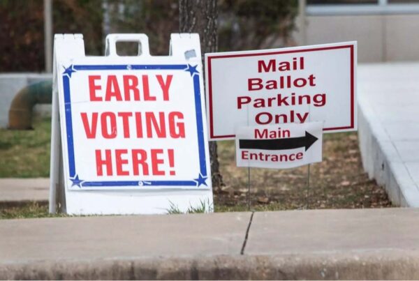 Signs that say "early voting here!" and "mail ballot parking only" outside a polling location