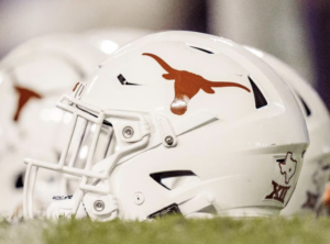 A close-up of a white football helmet with a burnt orange Texas Longhorns decal on the side of it