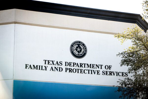 Exterior signage on a building shows the state seal of Texas above "Texas Department of Family and Protective Services"