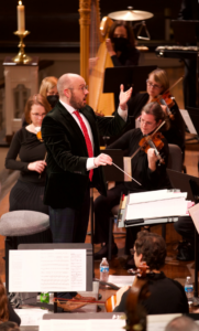 A photo of Taylor Scott conducting an orchestra.