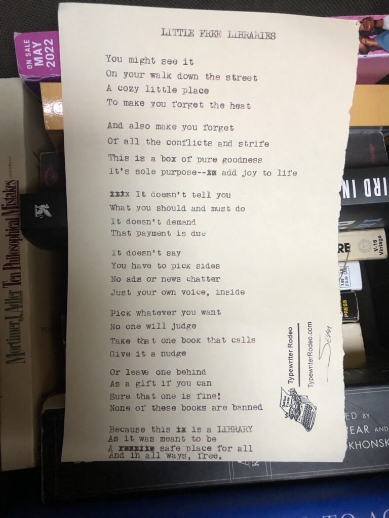 a photo of the typewritten poem on a torn half sheet of light yellow paper. the paper is sitting on a stack of books.