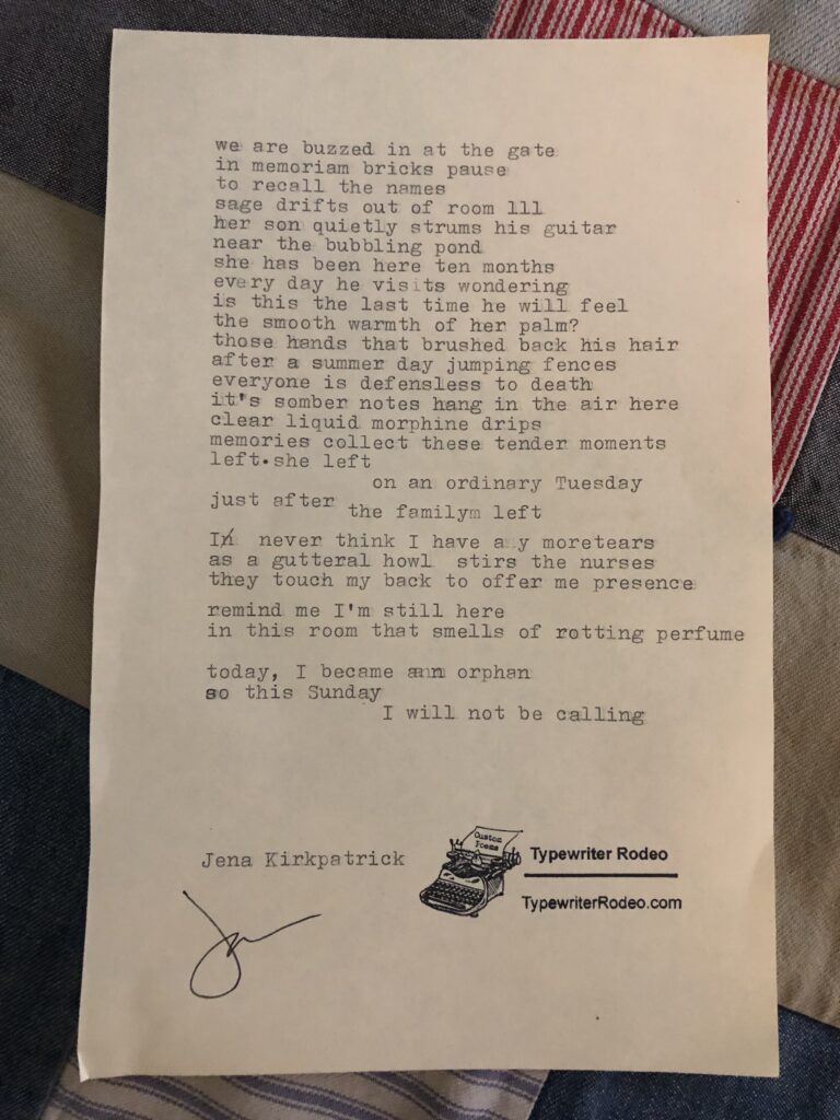 a photo of the typewritten poem on a torn half-sheet of yellowish paper. it rests on a quilted background.