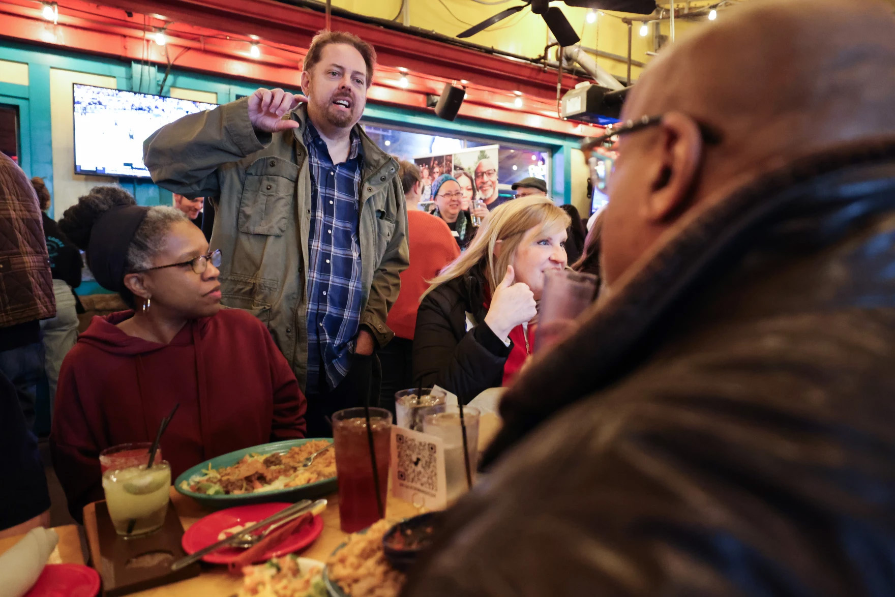 A man stands while speaking to people seated at a table. He is Jefferson Nunn.