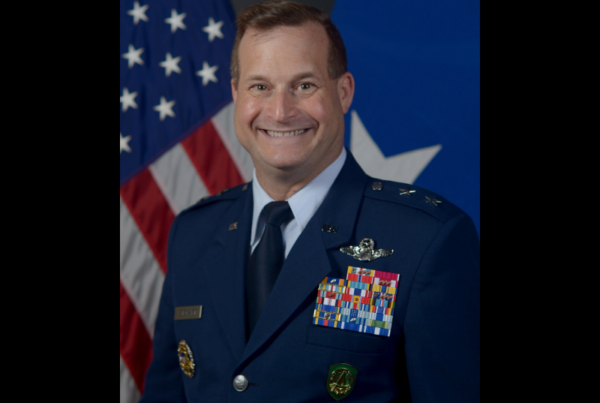 A uniformed general smiles while posing for his portrait in front of the U.S. flag. This is the official portrait of Major General Phillip Stewart.