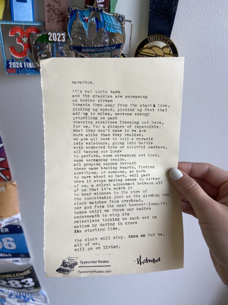 A photo of the typewritten poem on a torn half-sheet of yellowish paper. Behind the poem is a wall of running medals and paper running bibs