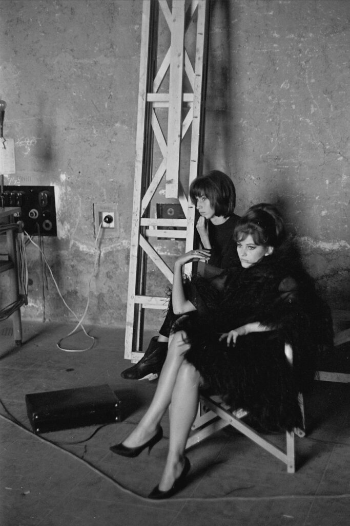 A black and white photo of two women in a backstage area.