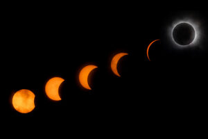 A photo shows six images of the moon in stages leading up to total eclipse.