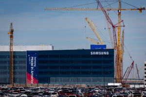 A large building that says "Samsung" in the top right corner is surrounded by construction cranes