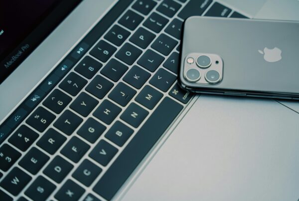 An iPhone is pictured face-down on a MacBook Pro keyboard