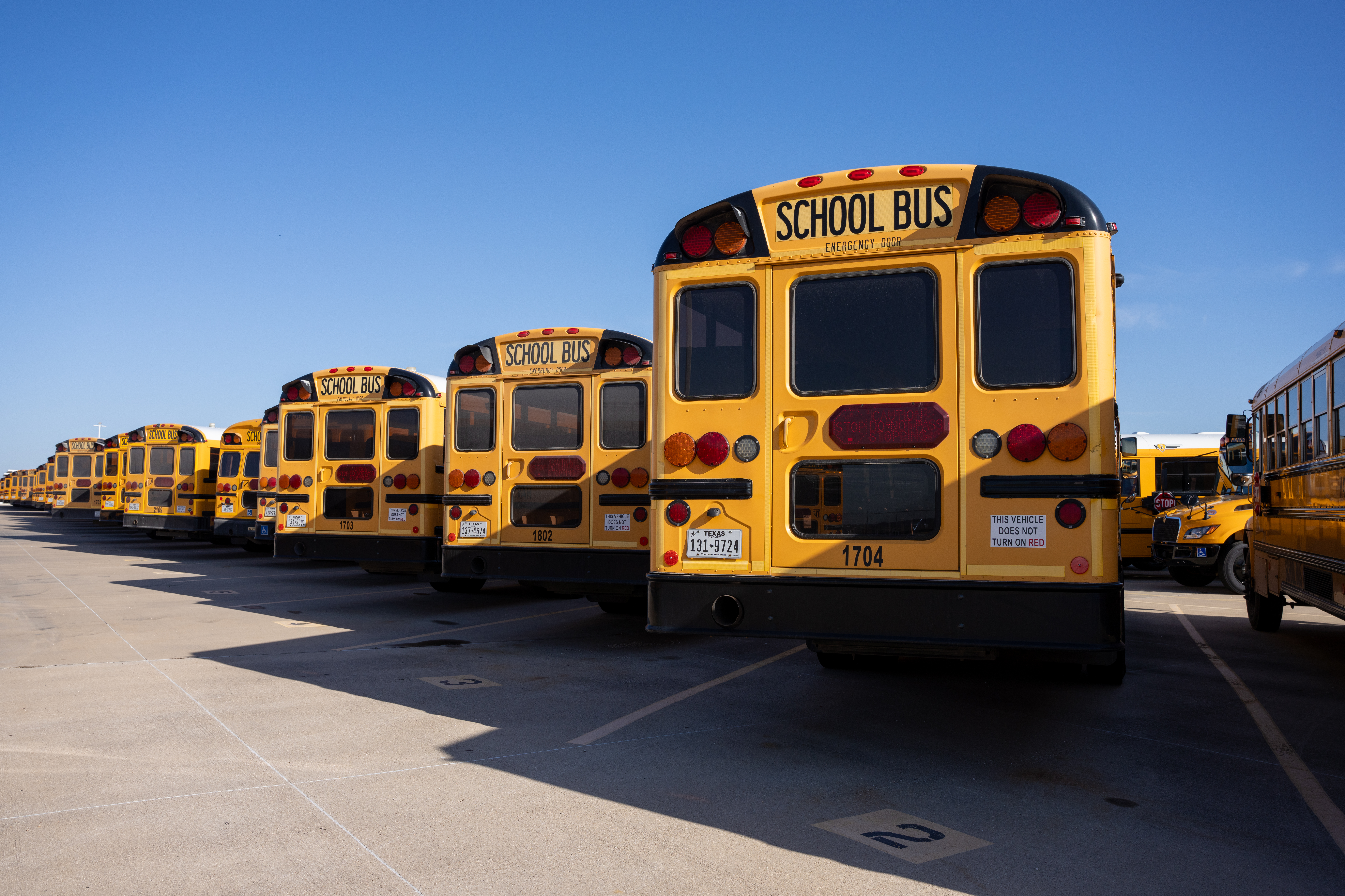 A parking lot full of yellow school buses.