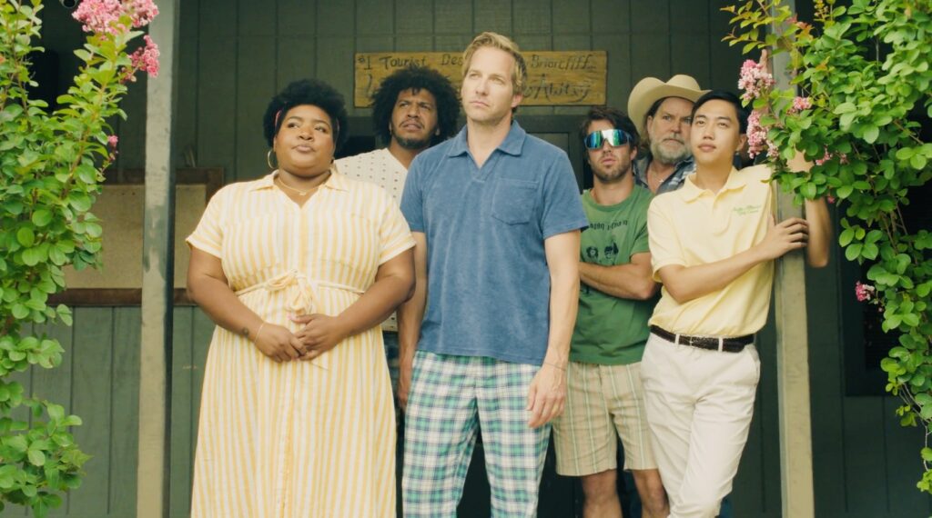 A still from the film "The Long Shot" shows a group of people standing on a porch.
