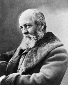 A black and white portrait of a bearded man in a fur-lined coat.