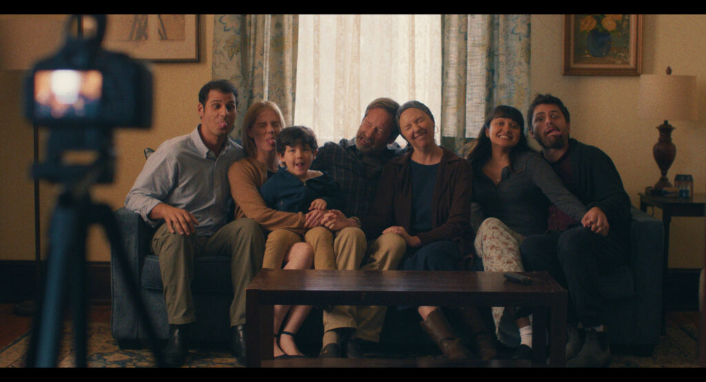 A still image from "See You When I See You" shows several people who appear to be posing for a photo on a couch.