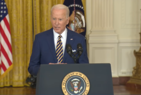 president biden speaking at a lectern with the seal of the president, and a yellow curtain and american flag in the background