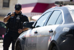 an austin police officer standing next to his patrol vehicle
