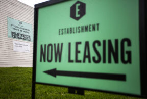 Closeup of a large "now leasing" sign